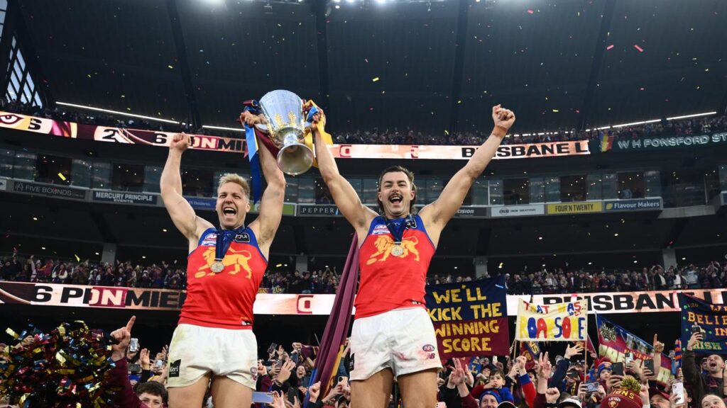 Oscar Allen and Sam Draper enjoying the sweet taste of grand-final success at the MCG.

