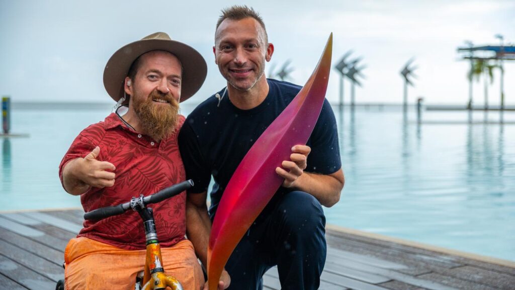 Paralympic swimmer Grant Patterson and Ian Thorpe with a piece of the Olympic emblem.
