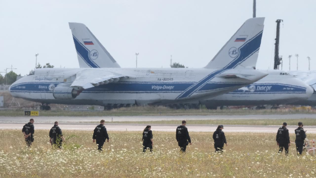 Police officers walk across the grounds of Leipzig Airport