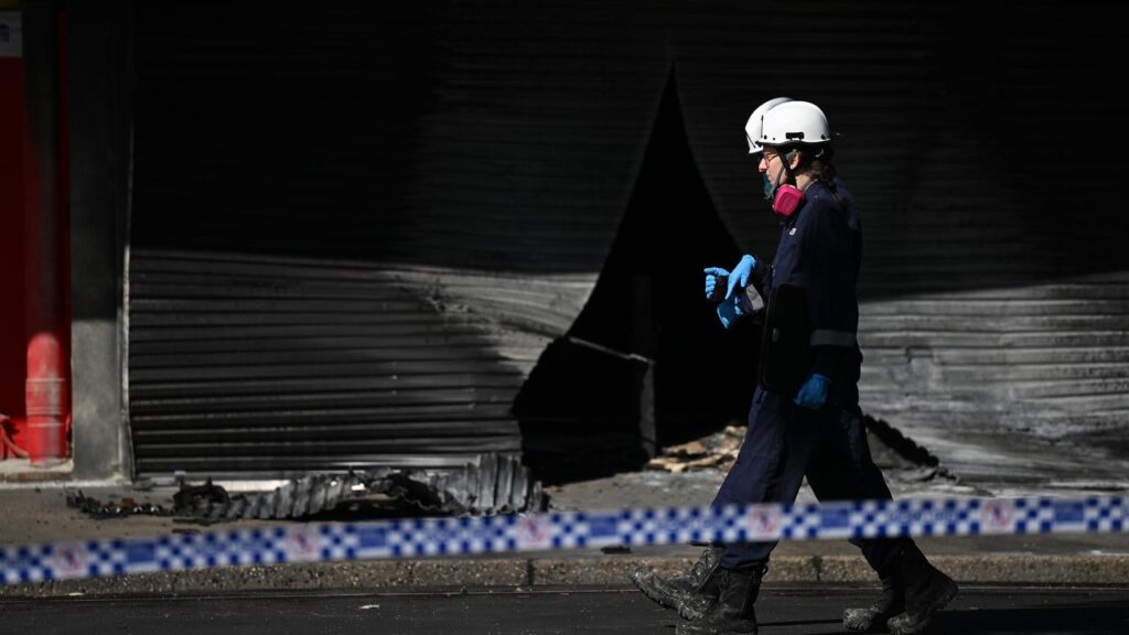 Authorities at the scene of the latest firebombing of a tobacco store in Melbourne.
