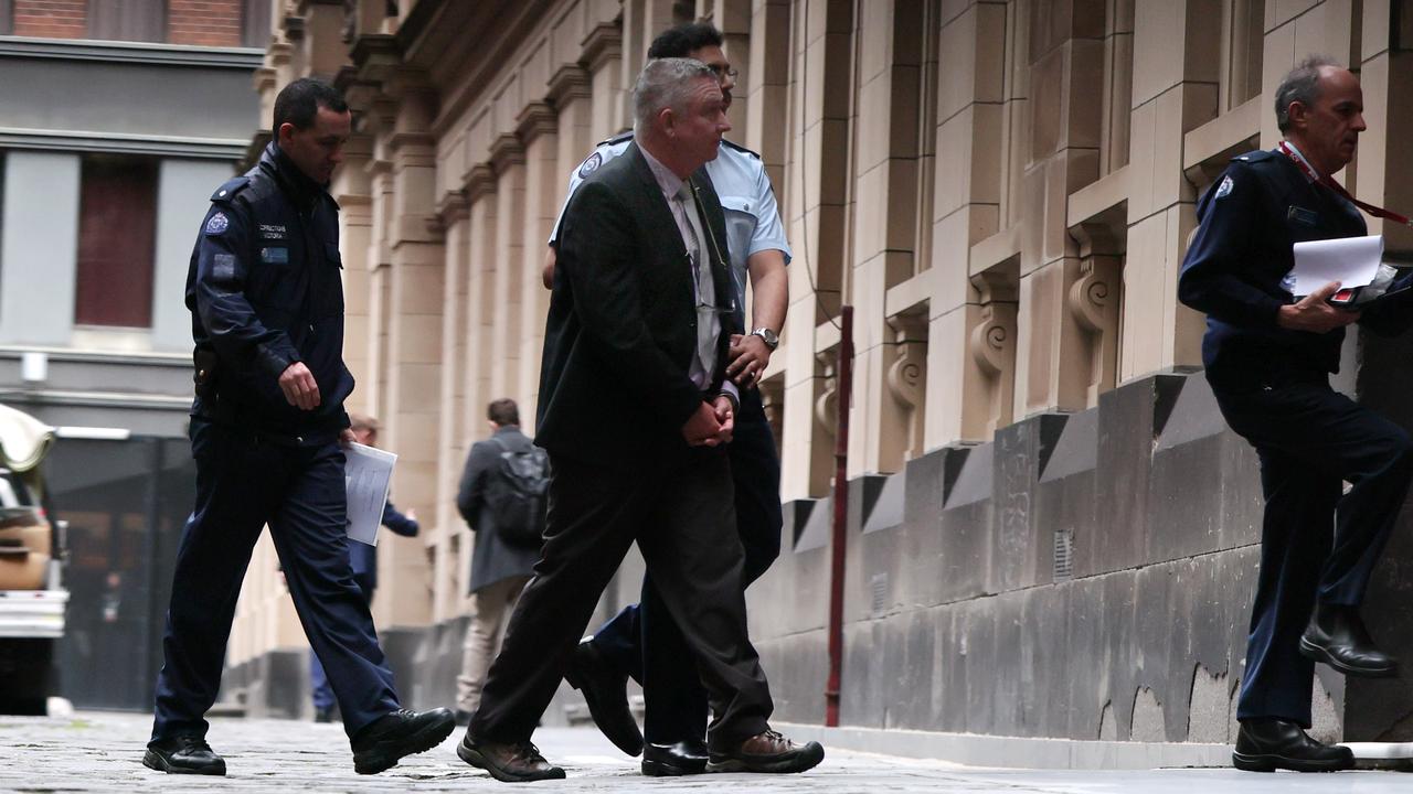 man walks into court with court officials