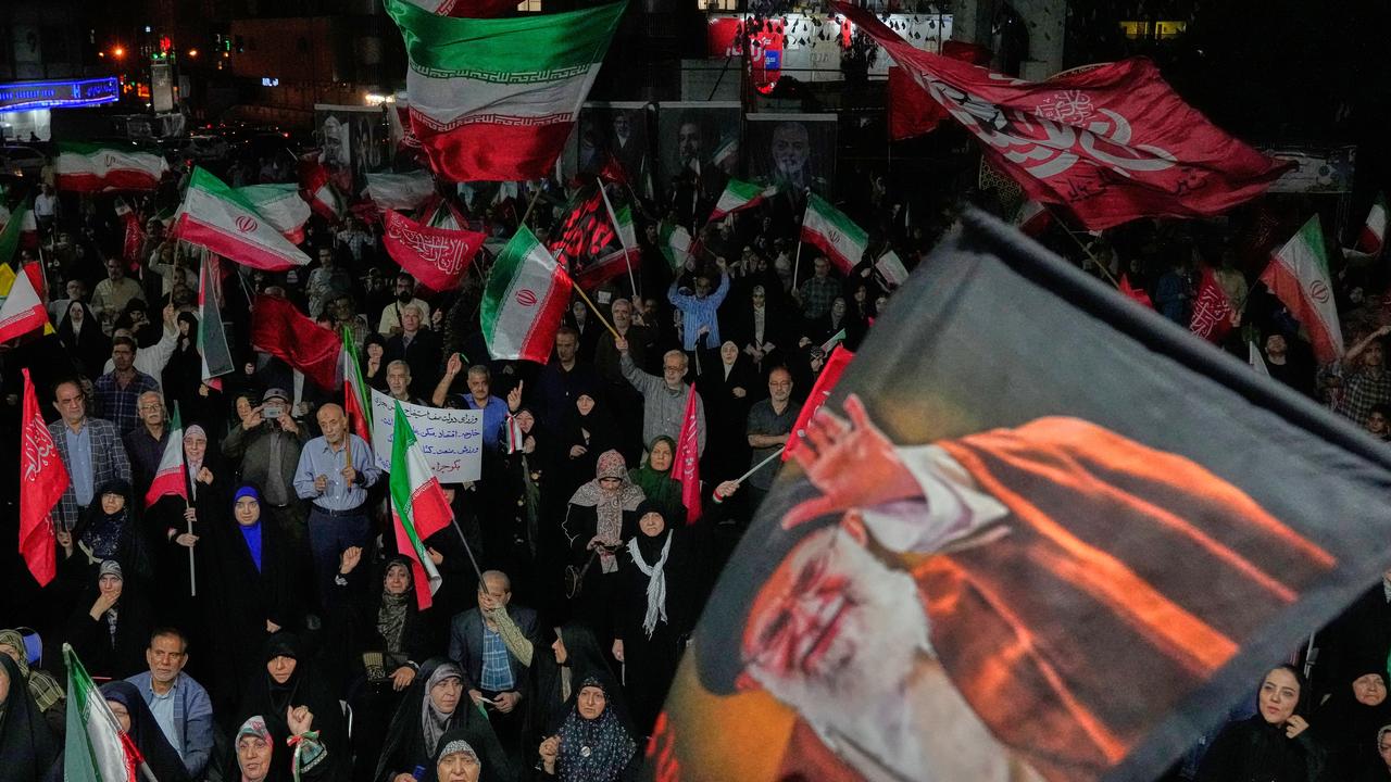 A flag of late Iranian Supreme Leader Ayatollah Ali Khamenei is waved.
