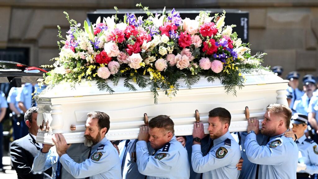 Mia Lay’s colleagues, including partner Daniel Vasquez (right), carry her casket from the church.
