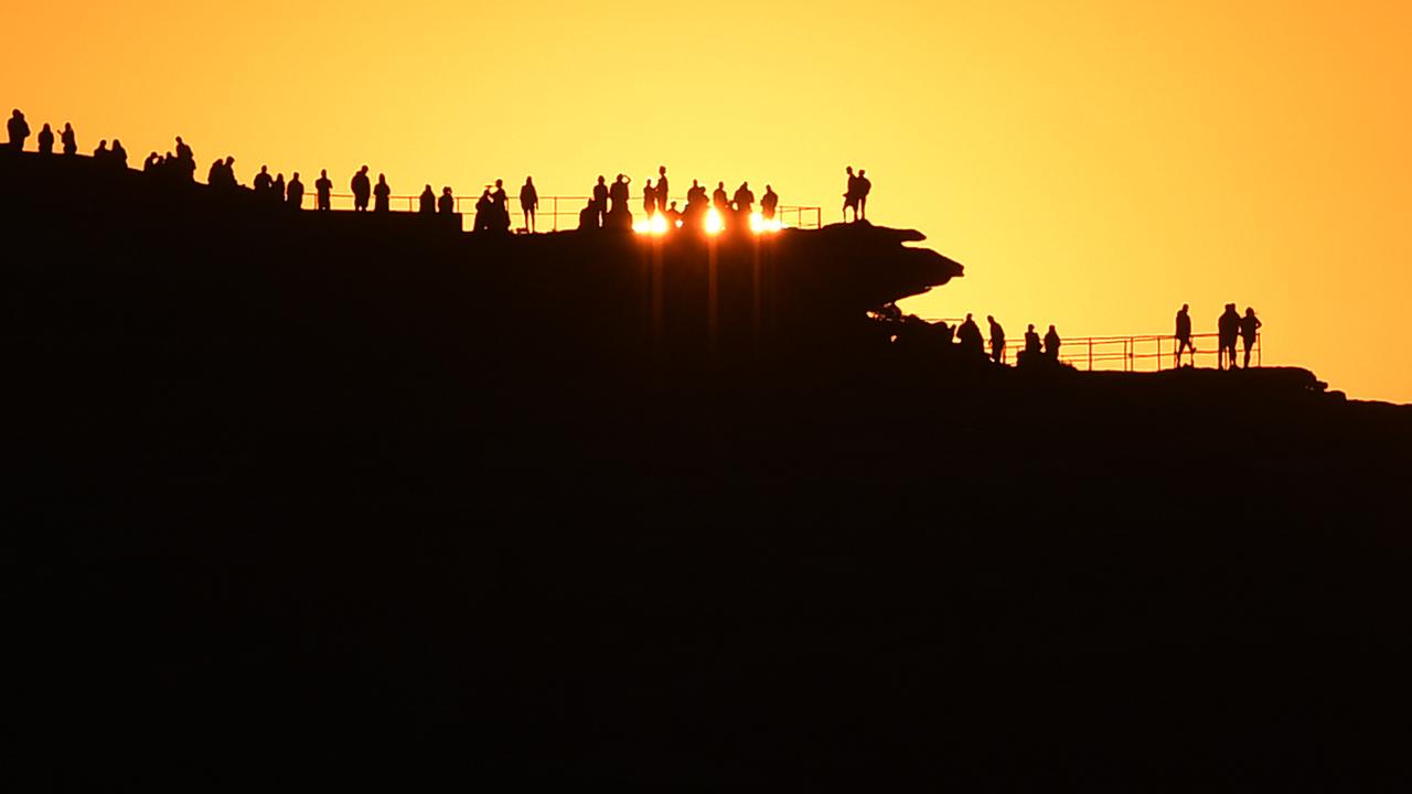 People watch sunrise at Bondi Beach in Sydney, NSW