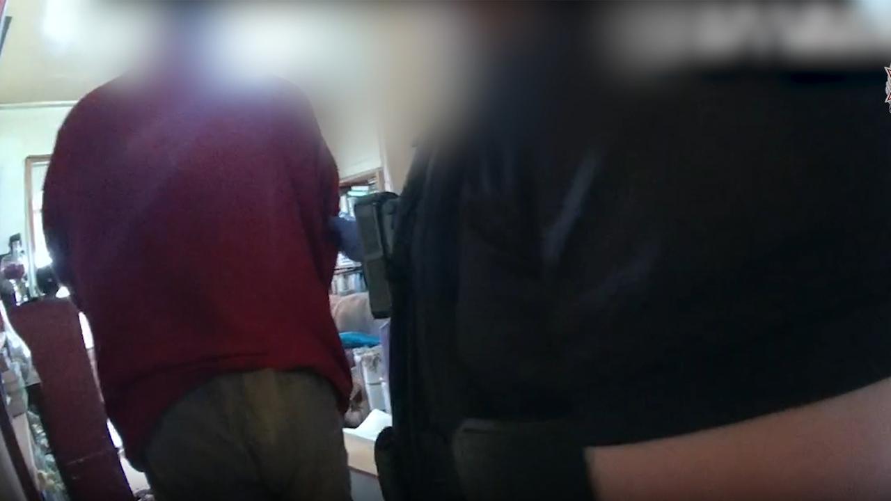 Queensland police arrest a man during the search of a property