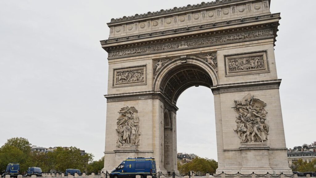 Police vans circle the Arc de Triomphe as authorities seek to prevent a replay of recent violence.
