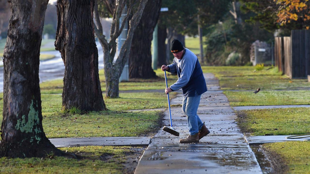 Cleaning a footpath following heavy rain (file)