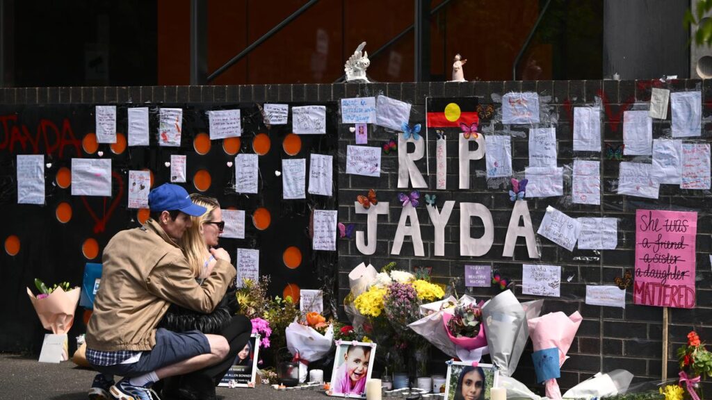 Flowers, photos, candles and handwritten notes have lined the entrance to an apartment block.
