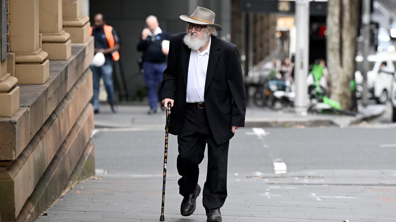 Man with hat and cane walks to court