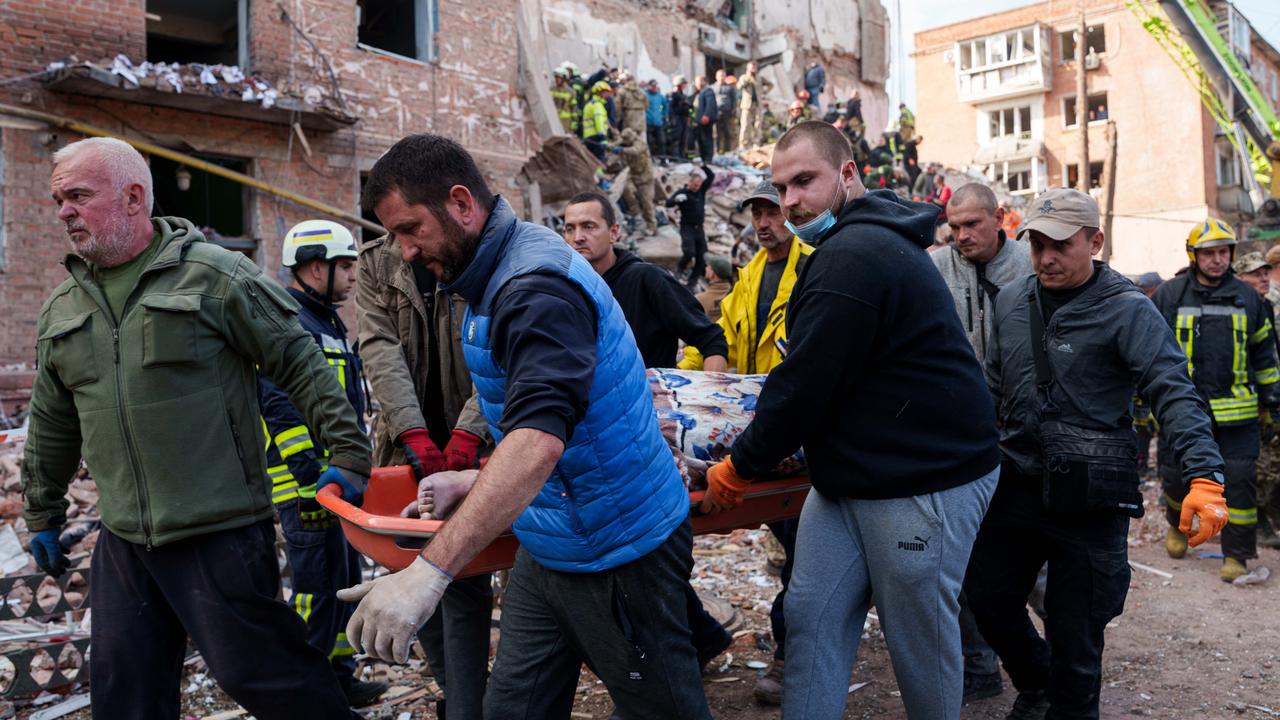 Locals carry a body after a Russian missile strike in Pryluky