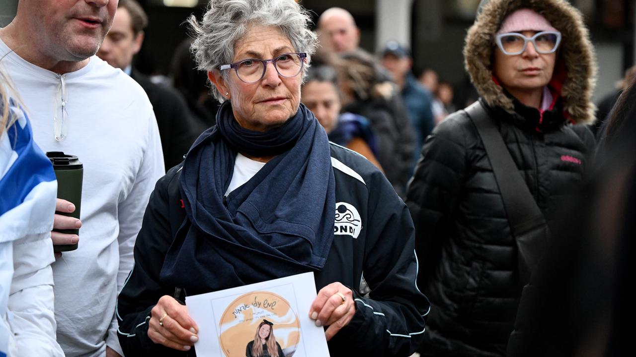 A woman holding a photo of an October 7 victim.