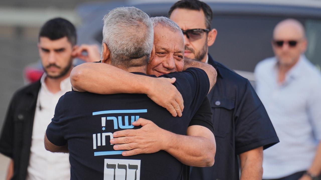 Gadi Eisenkot, Netanyahu's rival, is hugged at a polling station.