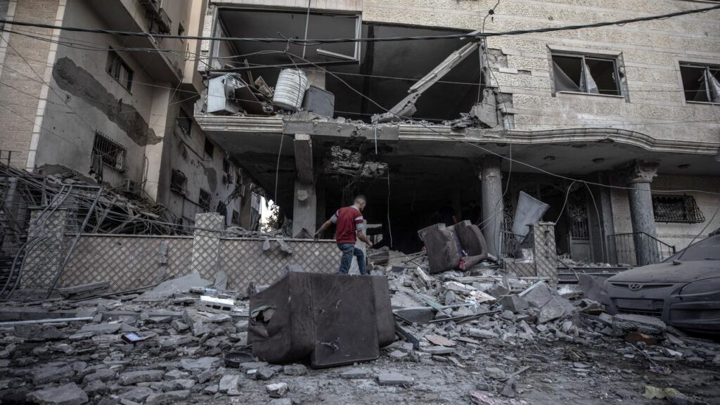 A Palestinian inspects a building destroyed in an Israeli air strike in central Gaza.
